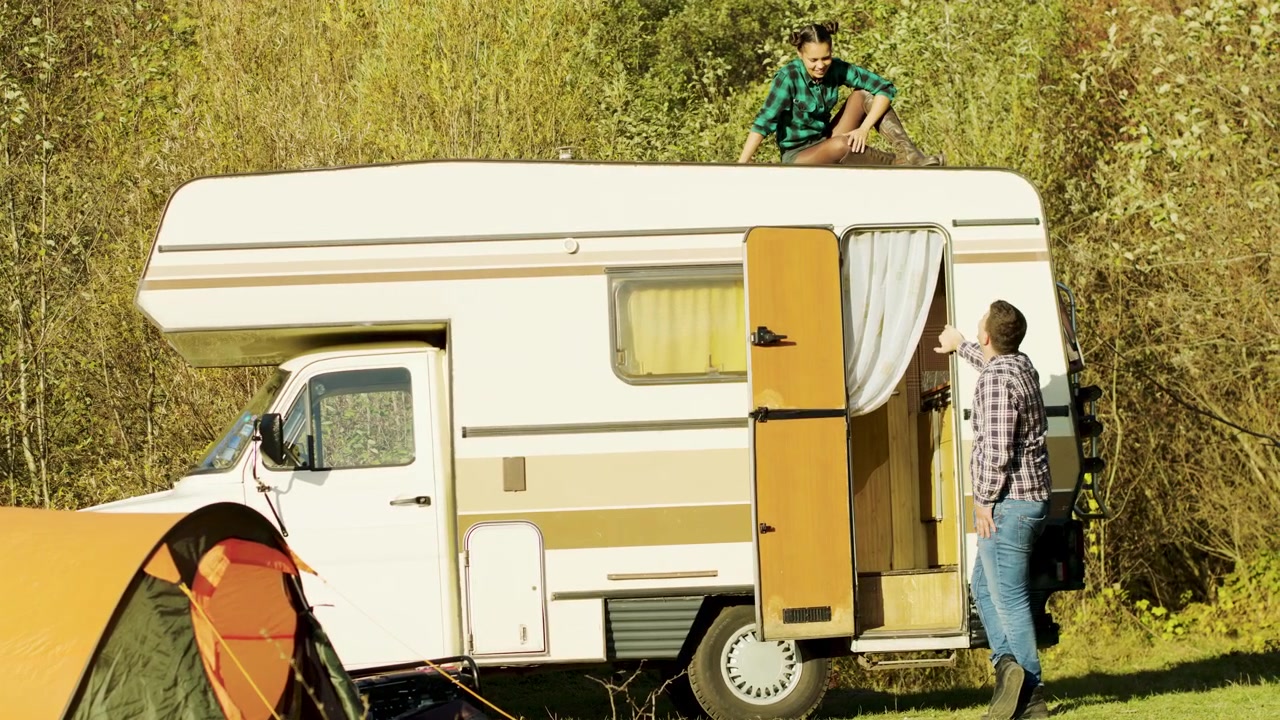 Esposa conversa com o marido do teto da autocaravana