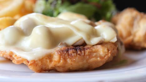 crispy breaded chicken parmesan with melted cheese and side salad