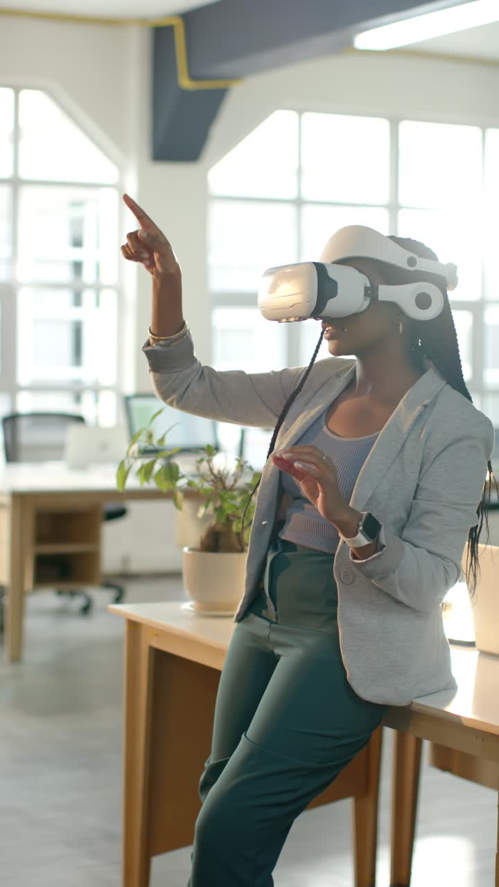 Vertikal video: Afroamerikansk kvinde tager headset på og udforsker virtuelt interface ved skrivebordet