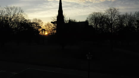 a low angle shot of a cathedral with a tall steeple during sunrise