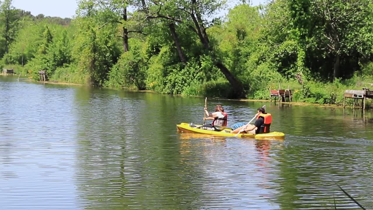 Two people kayaking on a peaceful river