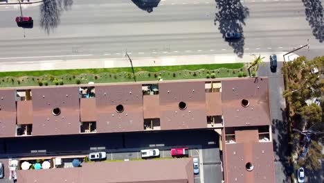 High-drone-shot-over-building-complex-with-cars-driving-on-road