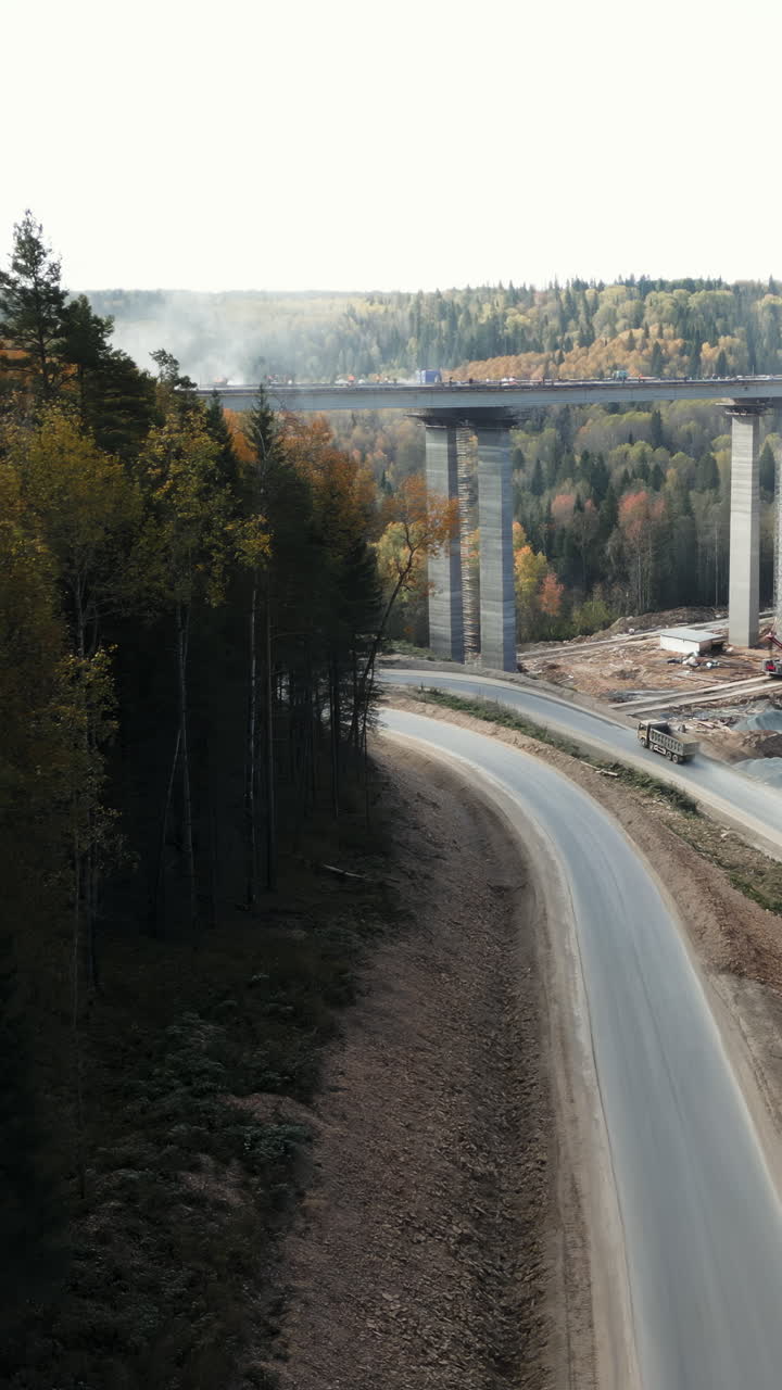 Viaduct under construction with trucks on the road