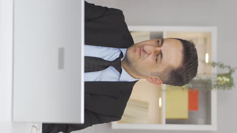 vertical video of home office worker man looking at camera with disgust and hatred.