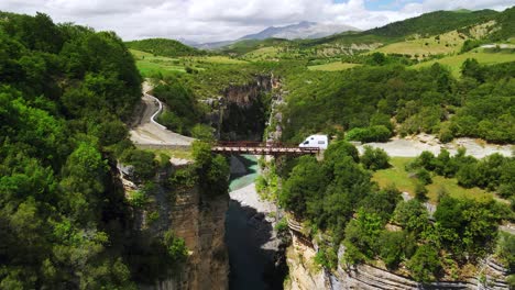 scenic aerial drone shot of the river flowing in between two rocky cliffs and canyons