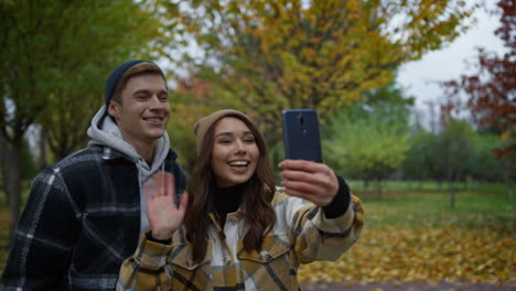 happy young couple making video call outdoors