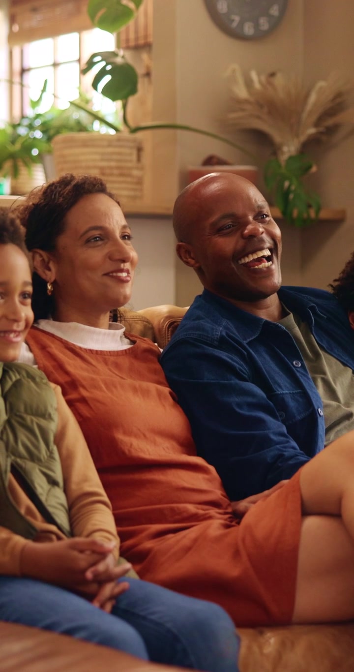Happy Family Watching Television Together in Living Room