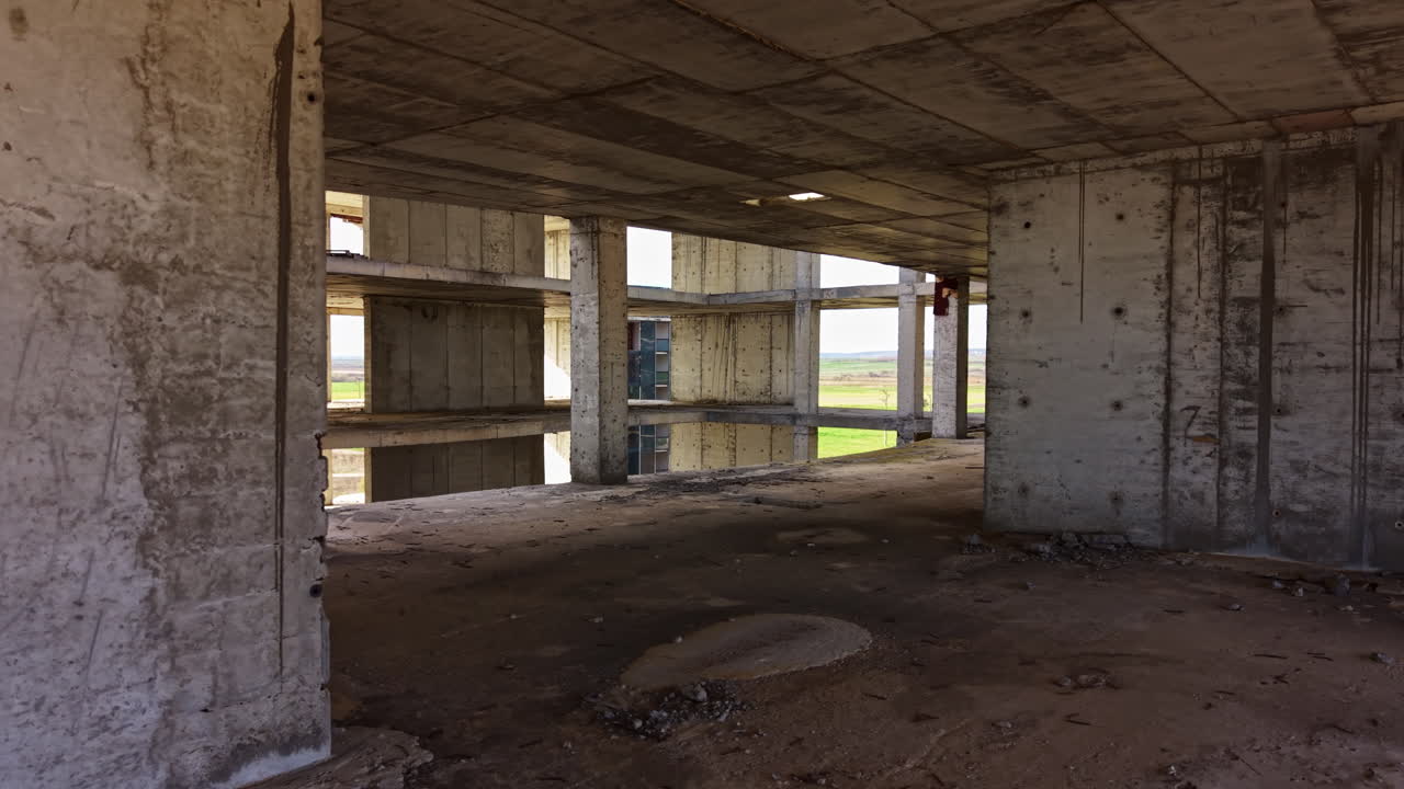 Esplorazione di un edificio abbandonato che rivela la sua struttura dimenticata e il passare del tempo sotto la luce intensa del sole in un paesaggio sereno