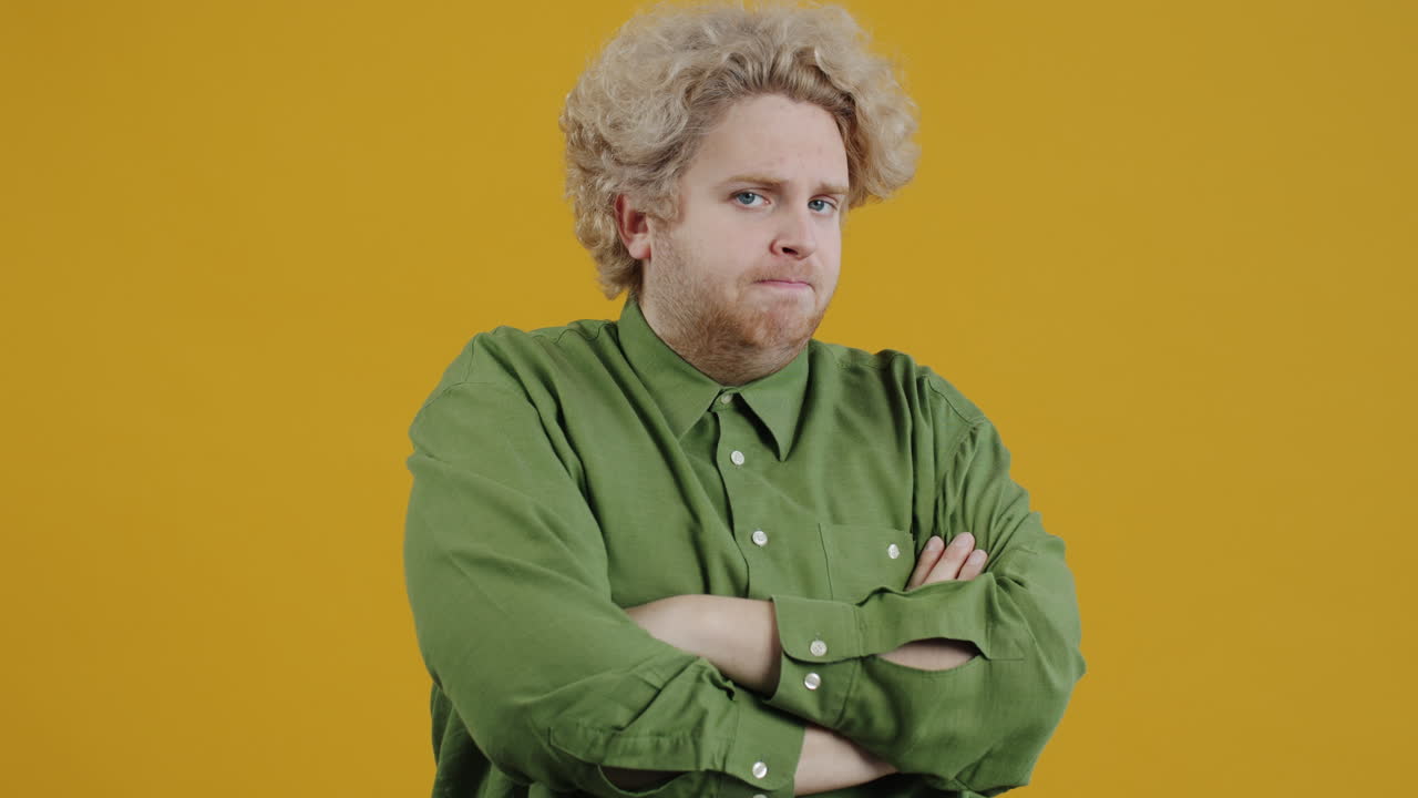 Man with arms crossed, wearing green shirt