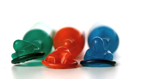 colourful condoms falling in front of blown up condoms