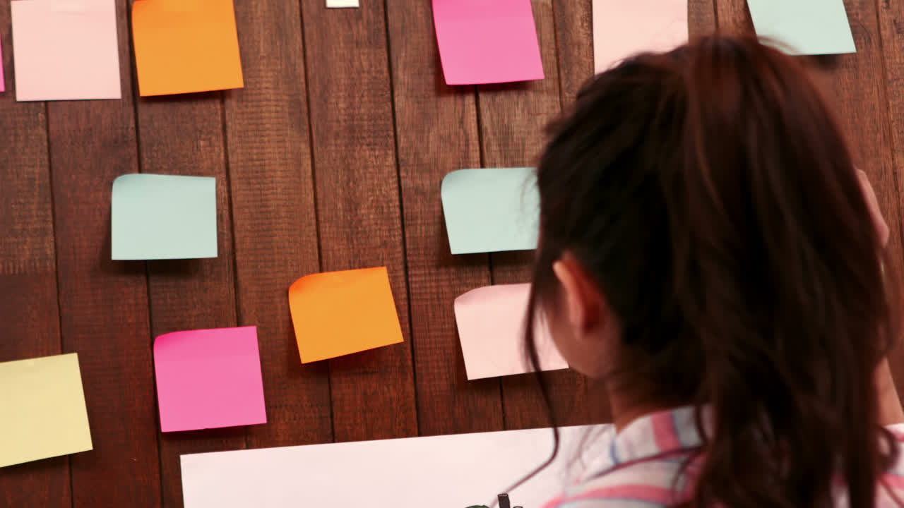 Pretty businesswoman moving post it