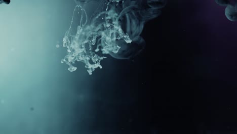 pintura de color claro estalló en el agua con fondo oscuro