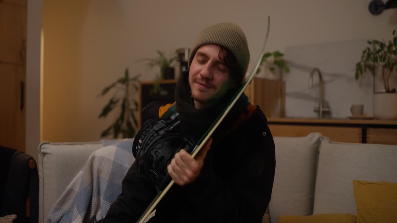 Uomo che si rilassa con il suo snowboard a casa