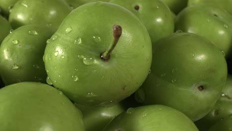 pile of fresh green plum on the market counter