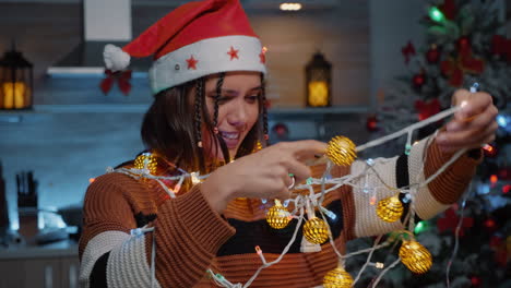 Cheerful-woman-laughing-at-tangled-rope-with-lights