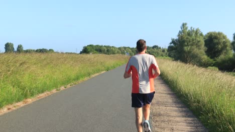 male trail runner on floodplains valley dyke