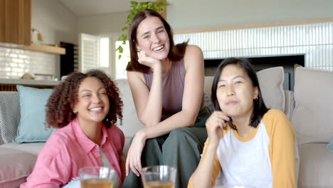 smiling and relaxing, three women friends enjoying time together at home