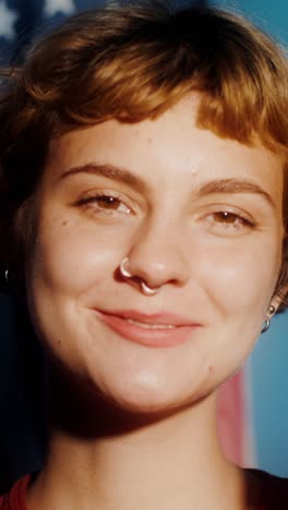 portrait of a young woman smiling in front of american flag