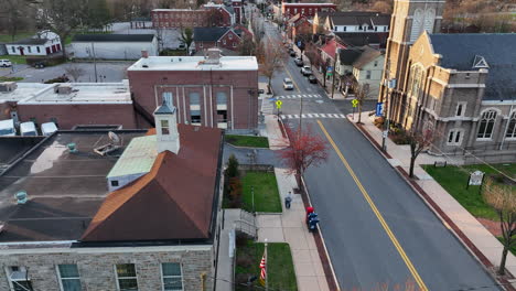 american flag at post office building by church and business buildings