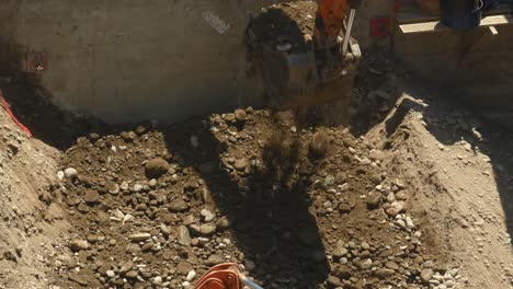 two excavators moving rocks debris and rubble