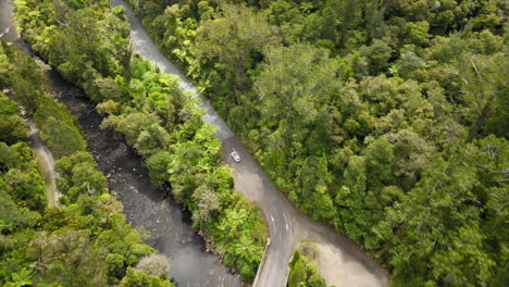 Es-Fängt-Einen-Atemberaubenden-Blick-Auf-Ein-Auto-Ein,-Das-Auf-Einer-Kurvenreichen-Straße-Durch-Einen-Dichten-Wald-Fährt