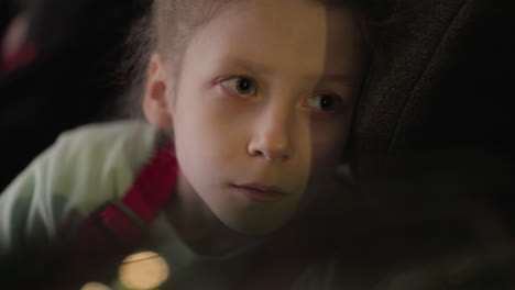 a close view of a child looking intently outside in a car, showcasing a thoughtful and pensive expression