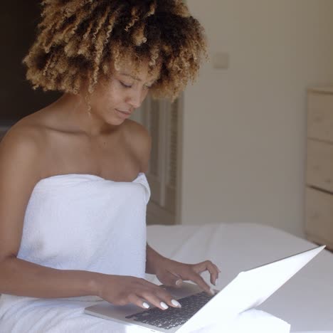 Junge-Frau-Mit-Laptop-Auf-Dem-Bett