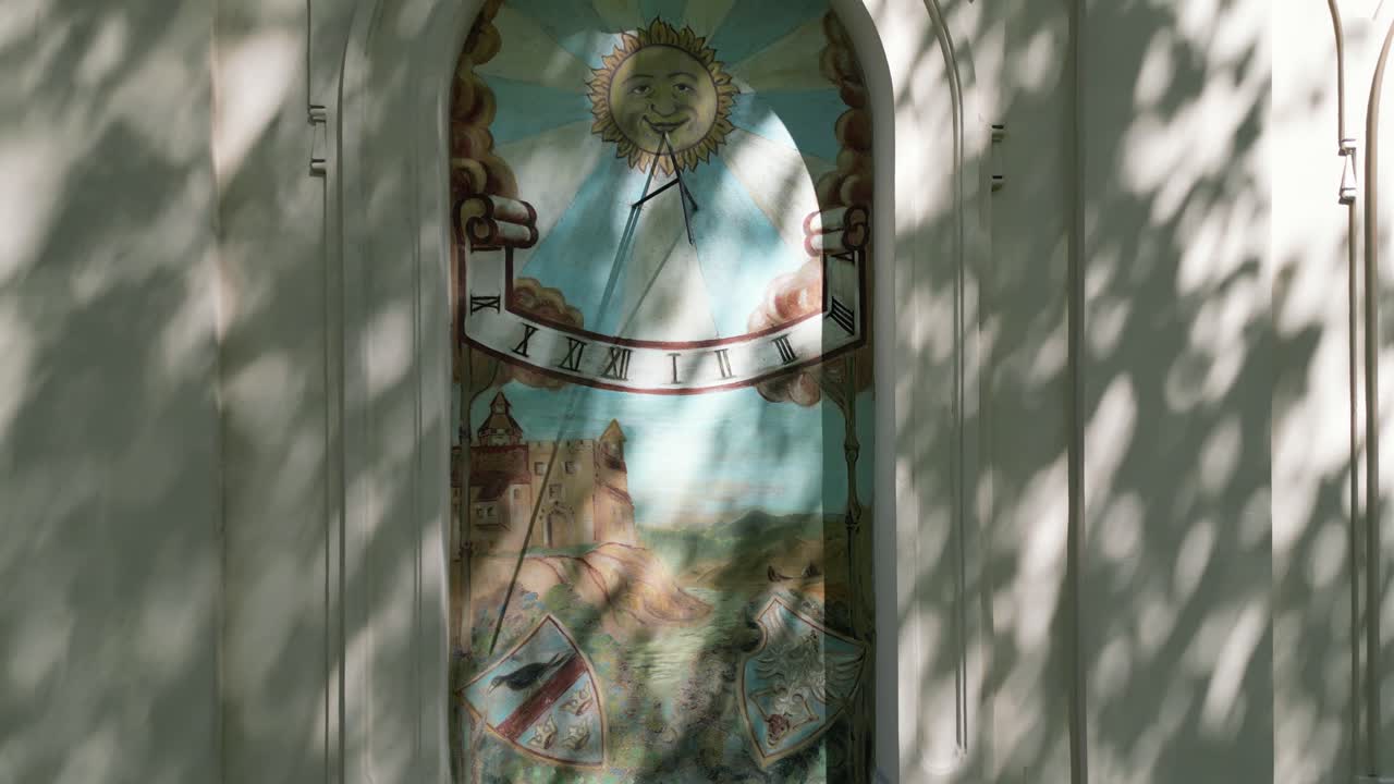 Artwork in the window of the facade of an old castle in Zywiec - sundial