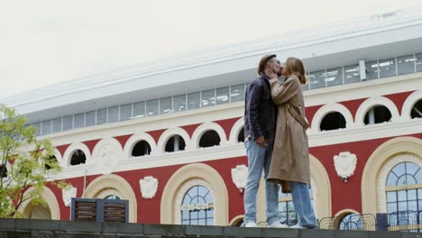 couple kissing and walking by a stadium