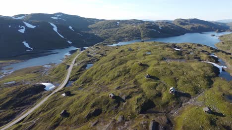 beautiful aerial view from top of mountain vikafjell - huts and leisure homes in majestic landscape and road rv13 passing beside freshawater lake skjelingavatnet