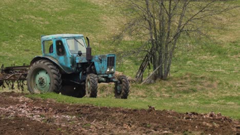 In-the-countryside,-driving-an-old-tractor-hard