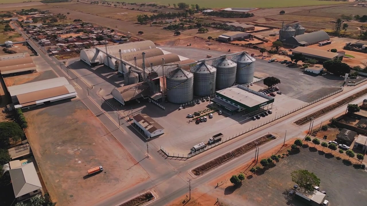 Vista orbital de alto ângulo de grandes silos de grãos em um armazém e centro de distribuição. Caminhões e máquinas agrícolas em Minas Gerais, Brasil.