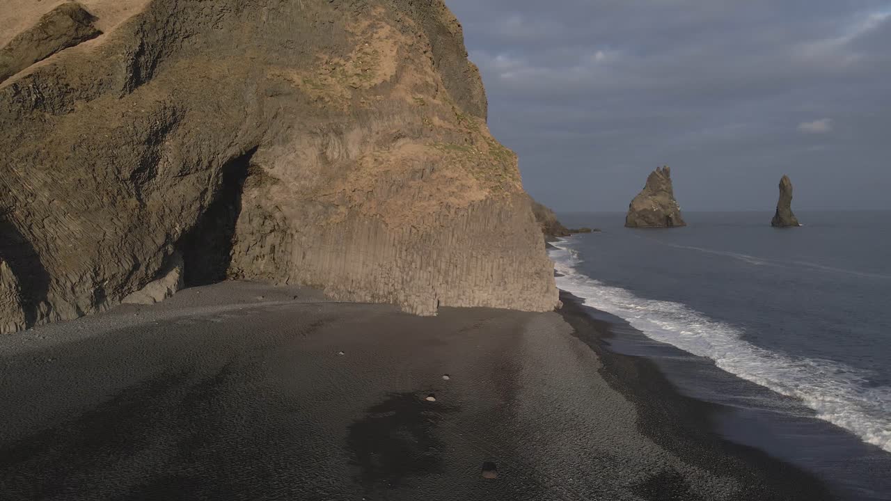 cueva de basalto en la playa de arena negra de reynisfjara, islandia
