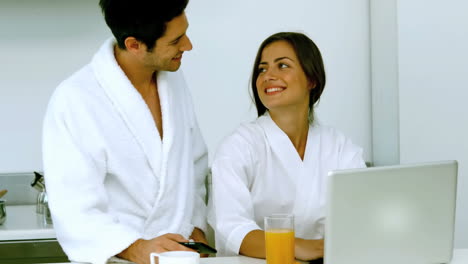 Cute-couple-having-their-breakfast-while-using-a-laptop