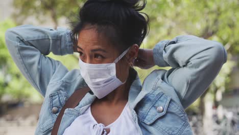 mixed race woman fixing medical coronavirus mask