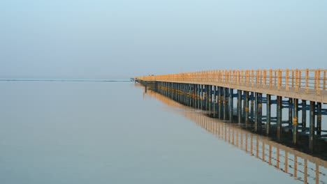 Still-View-Of-Wooden-Jetty-At-The-Beach-In-Sharm-El-Sheikh,-Egypt-With-People-Walking-In-A-Distance