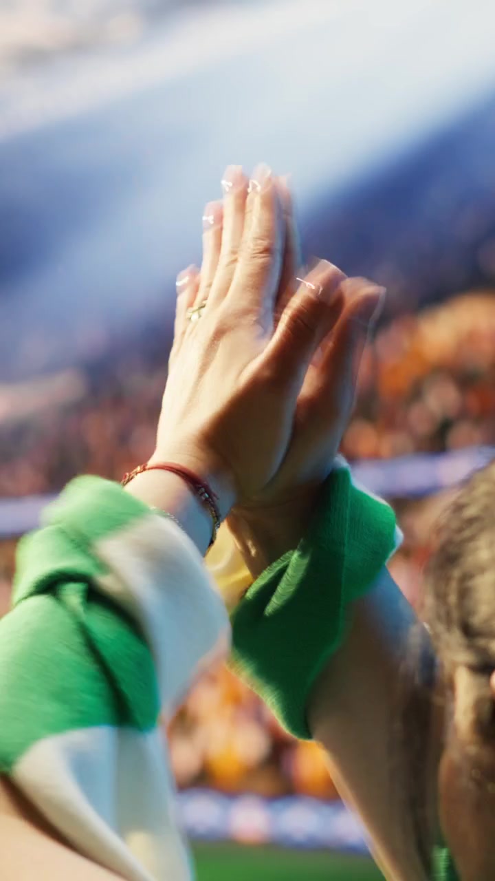 Video verticale. Primo piano di tifosi di calcio che applaudono nello stadio e battono un tamburo.