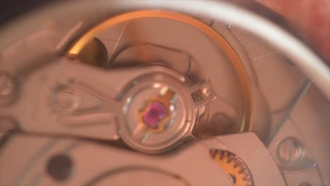 Macro-shot-of-running-clockwork,-gears-mechanism-working-and-spinning