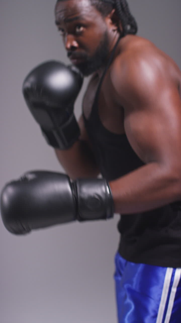 Vertical Video Studio Shot Of Male Boxer Sparring Working Out With Trainer Wearing Punch Mitts Or Gloves Practising For Fight 4