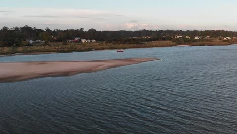 Drone-Volando-Sobre-Un-Río-Con-Un-Bote-Y-Pájaros-Volando-Alrededor