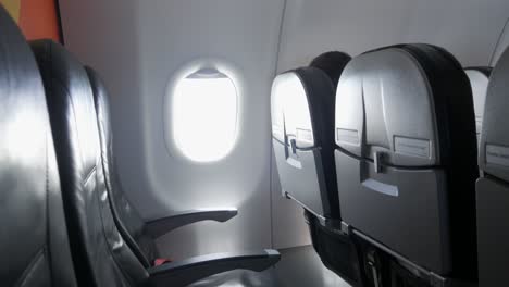 interior de la cabina vacía del avión comercial con asientos de pasajeros negros en la cabina de clase económica