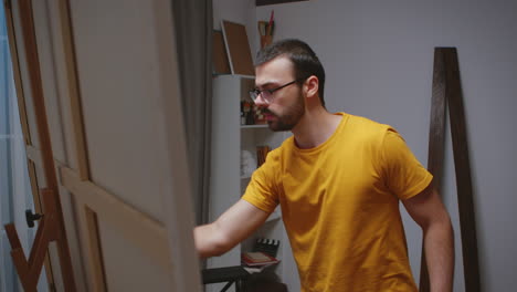 un tipo pintando en un lienzo grande.