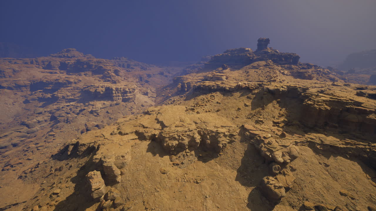 Rocky terrain in a desert landscape under clear blue sky during midday
