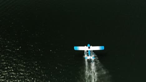 Antena-De-Arriba-Hacia-Abajo,-Hidroavión-Despegando-De-La-Superficie-Del-Agua-Del-Lago