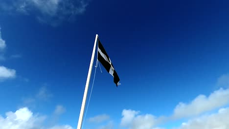 Cornish-flag-flying-high-against-a-blue-sky