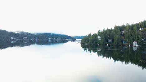 Toma-Aérea-Clara-Y-Brillante-Del-Fiordo-Del-Brazo-Indio-En-El-Norte-De-Vancouver-En-Un-Amanecer-Temprano-En-La-Mañana-Con-Reflejos-Poderosos,-Cala-Profunda