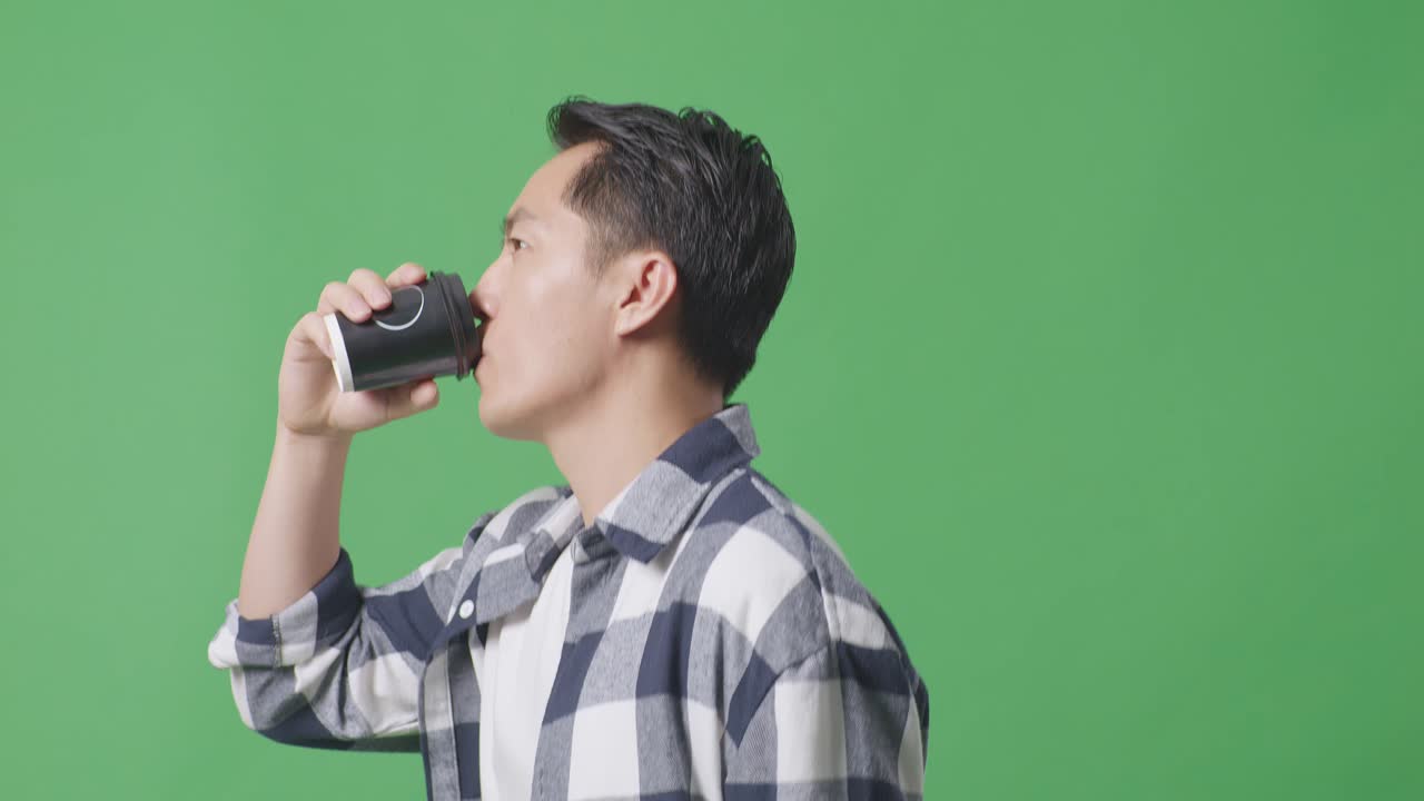 녹색 스크린 배경 에 산책 하고 커피 를 마시는 아시아인 의 측면 뷰 클로즈업