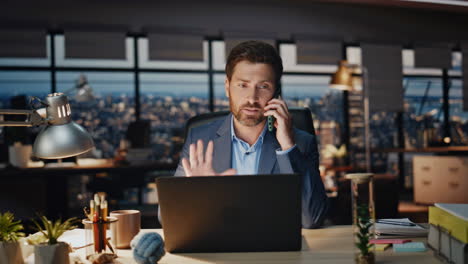 empresario sonriente hablando por teléfono celular en el interior de la noche. llamada telefónica del hombre