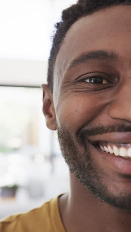 vertical video of portrait of happy african american man at home in slow motion