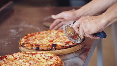 chef cutting pizza. chef cutting freshly prepared pizza